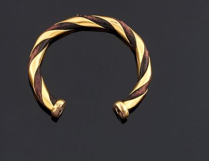 null HERMES
Bracelet rigide ouvert en métal doré et cuir à décor de torsades.
(Manges...