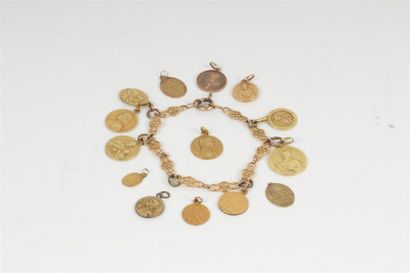 null LOT en or jaune 750°/oo et métal comprenant : un bracelet articulé orné de médailles...
