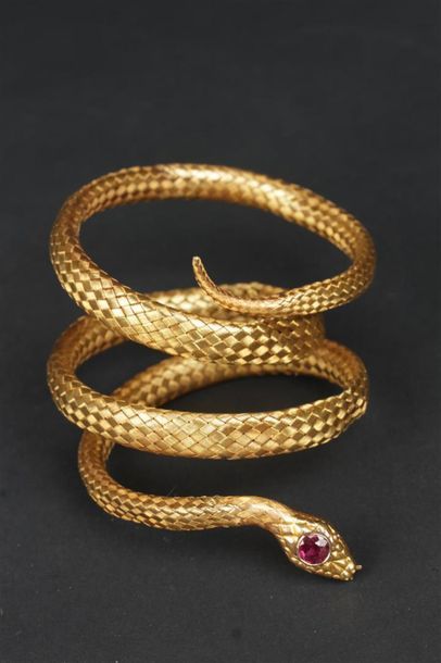 null BRACELET souple en or jaune 585°/oo tressé figurant un serpent, la tête ornée...