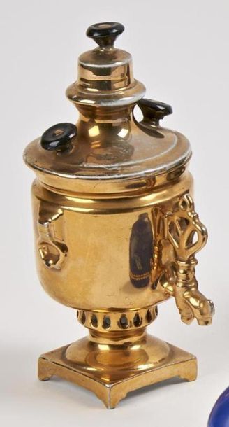 null KOUZNETSOFF
Samovar miniature en porcelaine dorée reposant sur une base carrée....