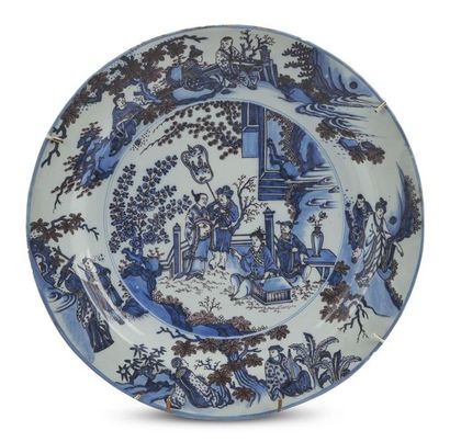 null Delft
Grand plat rond en faïence à décor en camaïeu bleu et manganèse de Chinois...