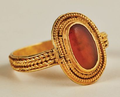 null Gold and amber ring. Oval kitten with cabochon surrounded by a double pearl...