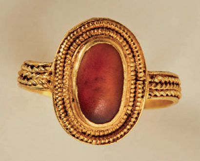 null Gold and amber ring. Oval kitten with cabochon surrounded by a double pearl...