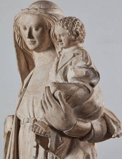 null Vierge à l'Enfant en pierre calcaire sculptée en ronde-bosse. Légèrement déhanchée,...