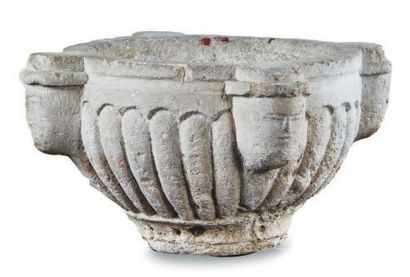 BENITIER in limestone with a gadronized body and four stylized head-shaped sockets....