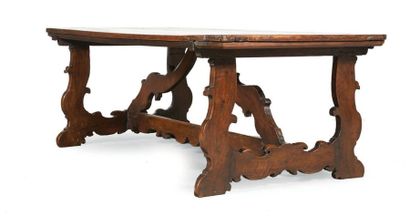 LARGE TABLE in walnut. Feet cut into lyre-shaped...