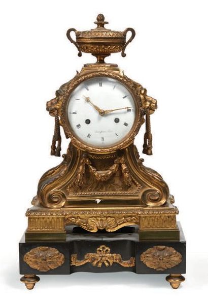 null Gilded bronze PENDER topped with an urn, black marble base, the dial signed...