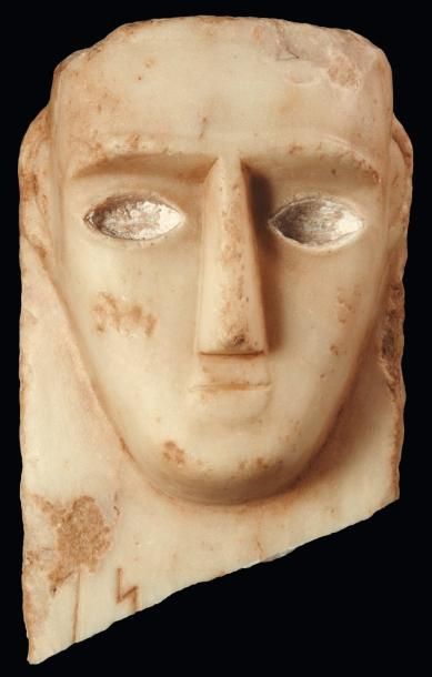 Orient Stèle iconique. Fragment de stèle sculptée d'un visage de face stylisé, présentant...
