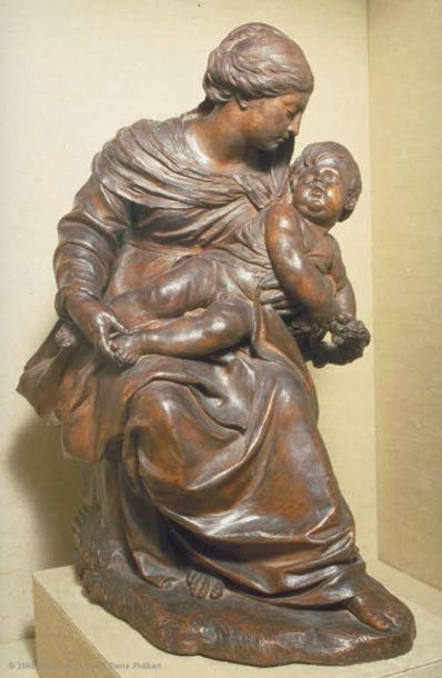 null Vierge à l'Enfant en bois fruitier sculpté en fort relief. La Vierge assise...