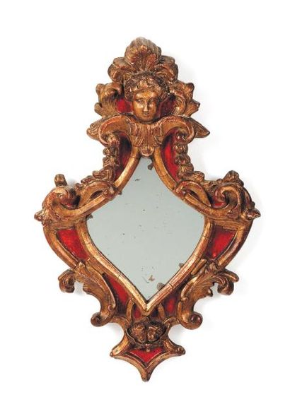 null Petit miroir de forme mouvementée en bois doré et peint en rouge. Italie, XVIIIe...