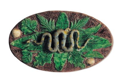 null Plat ovale à décor en relief au centre d'un serpent sur des feuilles entouré...
