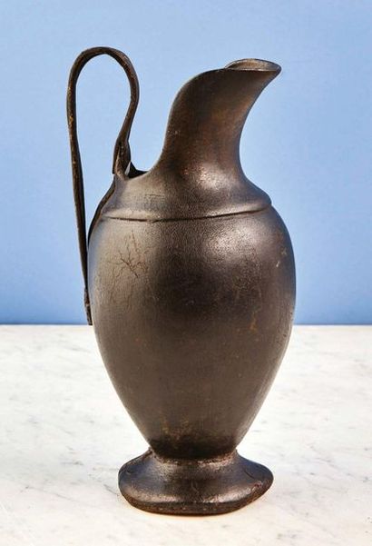 null Rare brown leather ewer and iron handle painted brown with gold traces, the...