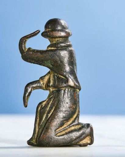null LITTLE ANGEL in bronze, old support. One knee on the ground, he raises his left...