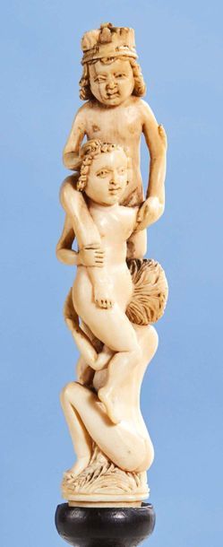null Handle of a finely carved ivory knife or fork depicting three child acrobats...