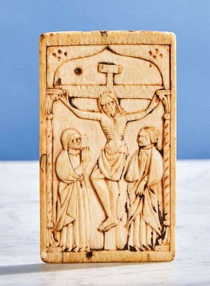  Ivory plaque carved in shallow depth representing the Crucifixion. Under a bracket...