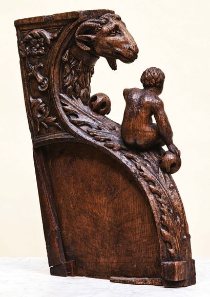 null Carved oak frame decorated with a ram's head wearing a necklace from which bells...