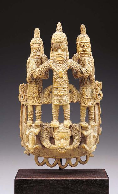 null An ivory pendant carved in high relief in the form of a shield with a young...