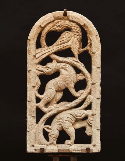 null Arched window in carved and openwork stone. Decorated with a sinuous scroll...