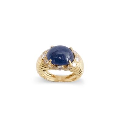 null An 18K (750) yellow gold ring with a cabochon sapphire surrounded by brilliant-cut...