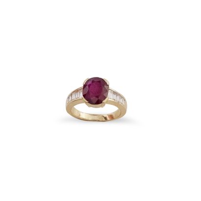 null Bague en or jaune 18K (750) ornée d'un rubis ovale épaulé de diamants baguette....