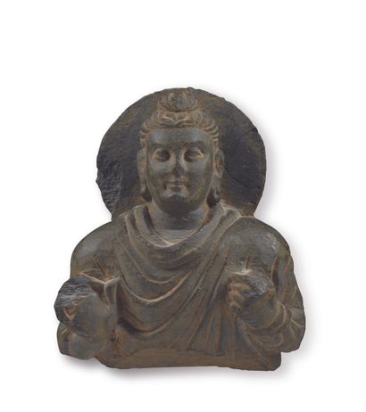 null BUST OF BUDDHA in grey schist, hair up in a bun, robe pleated, the left point...