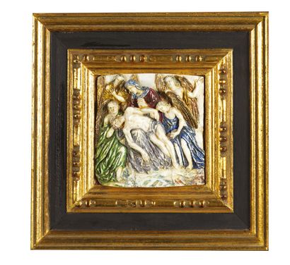  An ivory plaque carved in high relief and polychromed representing the Lamentation....
