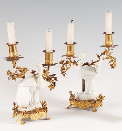 null Coppia di candelabri a due luci in bronzo dorato, decorati con pavoni in porcellana...
