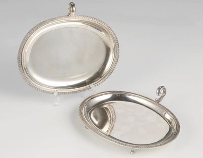  Una coppia di vassoi in argento 800 di forma ovale, poggiante su quattro piedi caprini,...