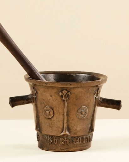  Bronze mortar and pestle. Body with six buttresses topped with a fleur-de-lys; medallion...