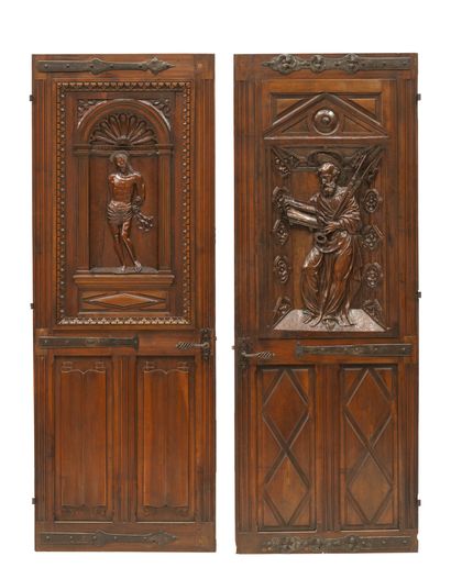 Two walnut doors. One decorated with a Saint...