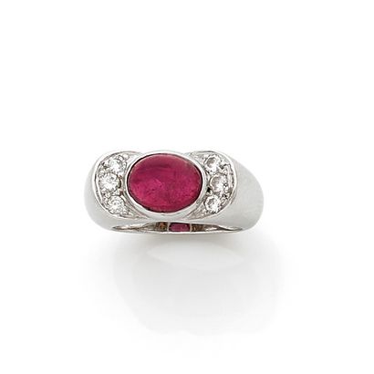 null An 18K (750) white gold ring set with a cabochon rubellite and three brilliant-cut...