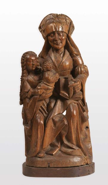  SAINTE ANNE TRINITAIRE en chêne sculpté, dos évidé. Assise, Anne retient de son...