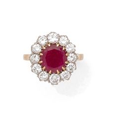 null Daisy ring in 18K (750) gold and platinum (850), set with an oval ruby in claw...