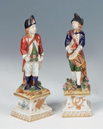 null Deux statuettes en porcelaine polychrome et dorée représentant un soldat batteur...