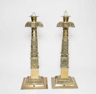 null Pair of ormolu and chased candlesticks with decorative and stylized motifs resting...