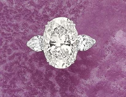 null A Diamond Ring Set to the center with an oval-cut Diamond weighing approximately...