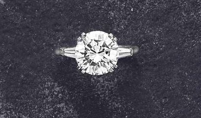 null A Diamond Ring center ing upon a circular-cut Diamond weighing approximately...