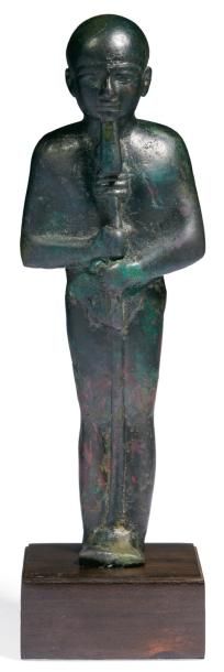 ÉGYPTE STATUETTE VOTIVE REPRÉSENTANT LE DIEU PTAH. Il est debout, le corps étroitement...