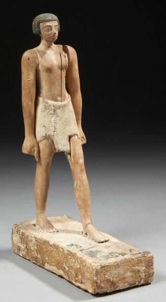 EGYPTE STATUETTE DE DIGNITAIRE. Elle représente un homme debout sur une base, dans...