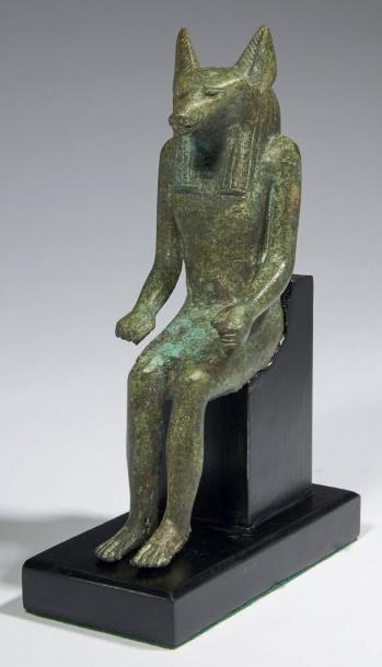 Égypte STATUETTE D'ANUBIS. Statuette votive représentant le dieu Anubis. Il est assis,...