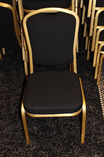 null Suite de cent chaises empilables en métal doré, assise et dossier garnis de...