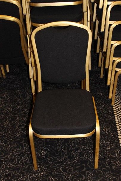  Suite d'environ 80 chaises empilables en métal doré, assise et dossier garnis de...