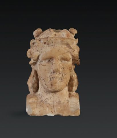  SOMMET DE PILIER HERMAÏQUE. Sommet de pilier hermaïque représentant la tête de Dionysos...