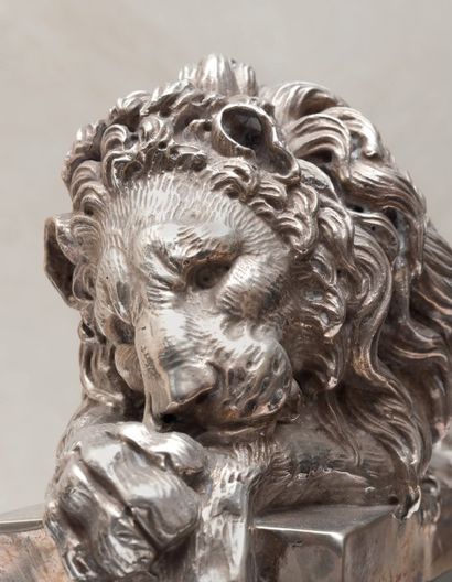 null Paire de lions en argent repoussé sur des socles moulurés en marbre noir incrustés...