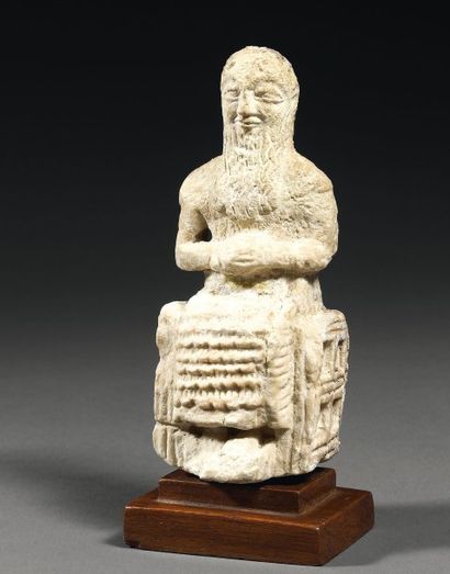 null Rare statuette d'orant. Elle représente un homme barbu assis sur un siège. Il...