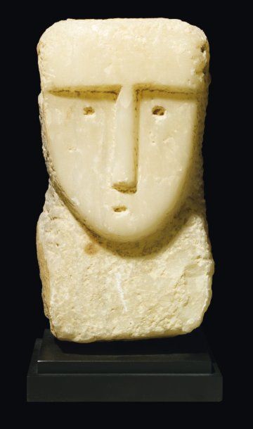 Stèle iconique sculptée d'un visage de face...