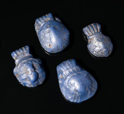 null Ensemble composé de quatre pendentifs en forme de tête du dieu Bès. (4 objets)....
