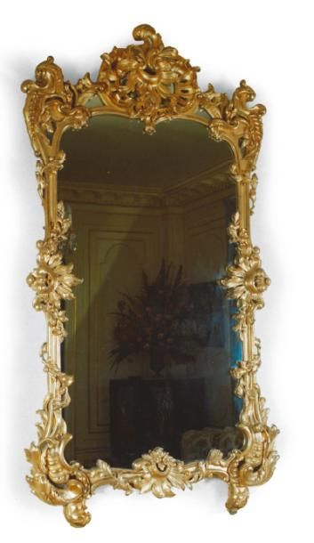  MIROIR à encadrement en bois sculpté et doré, à décor feuillagé. Style Louis XV,...