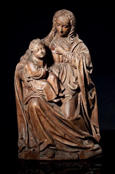 null Vierge allaitante en chêne sculpté en ronde-bosse. Assise sur un banc, Marie...