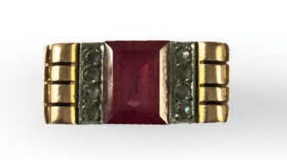 null BAGUE en or 18K (750), ornée d'une pierre rouge rectangulaire épaulée de deux...